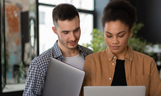 Man and woman looking at laptops